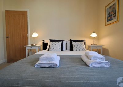 Folded towels on grey bed linen.