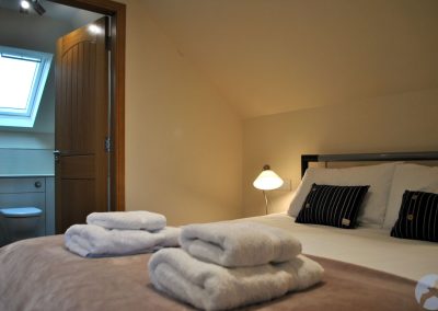 The open door to the en-suite shows a Velux-style roof window above the lavatory.