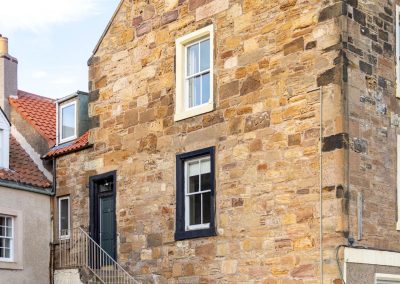 Gable end of house with steps leading up to a foor on the first floor.