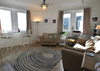 Large, bright lounge with a variety of furniture.