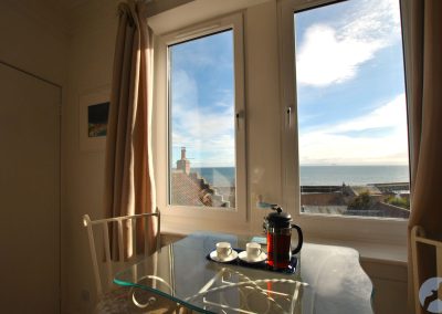 View across glass-topped table out of window towards the sea.