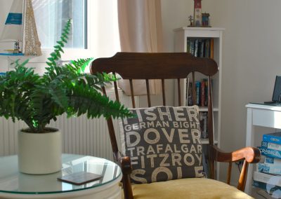 Rocking chair with a cushion showing names from the BBC shipping forecast.