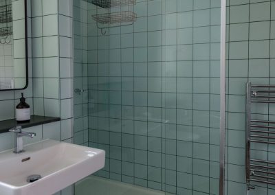 Walk-in shower surrounded by tiles and glass.