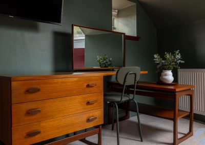 Desk area beneath a TV and a small window.