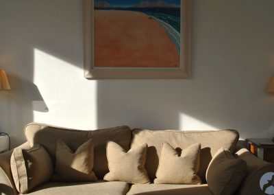 Close up of sofa with painting hanging above it.