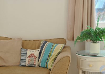 Round table with plant to right of sofa.