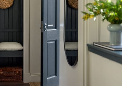 View down the hallway towards an open front door.