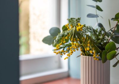 Close up of a vase of flowers on a windowledge.